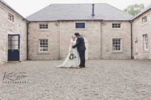 Bride and groom infront of the Coach house