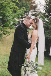 Bride and groom with foreheads together in the garden at the Gailes