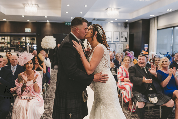 Bride and groom kissing in ceremony room