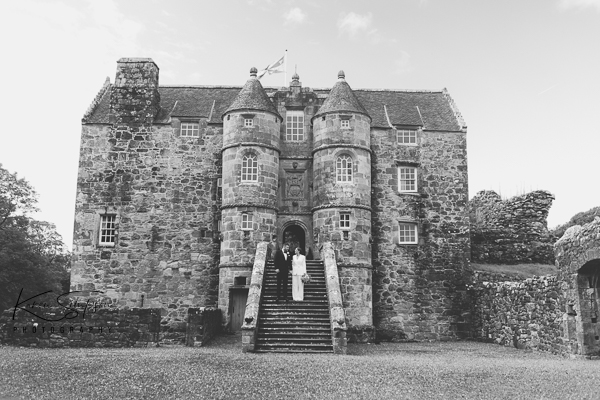 Black and white photo bride and groom infront of old castle at Rowallan