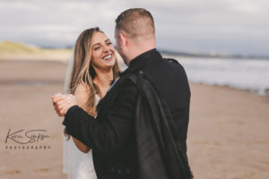 Bride and groom down Irvine Beach